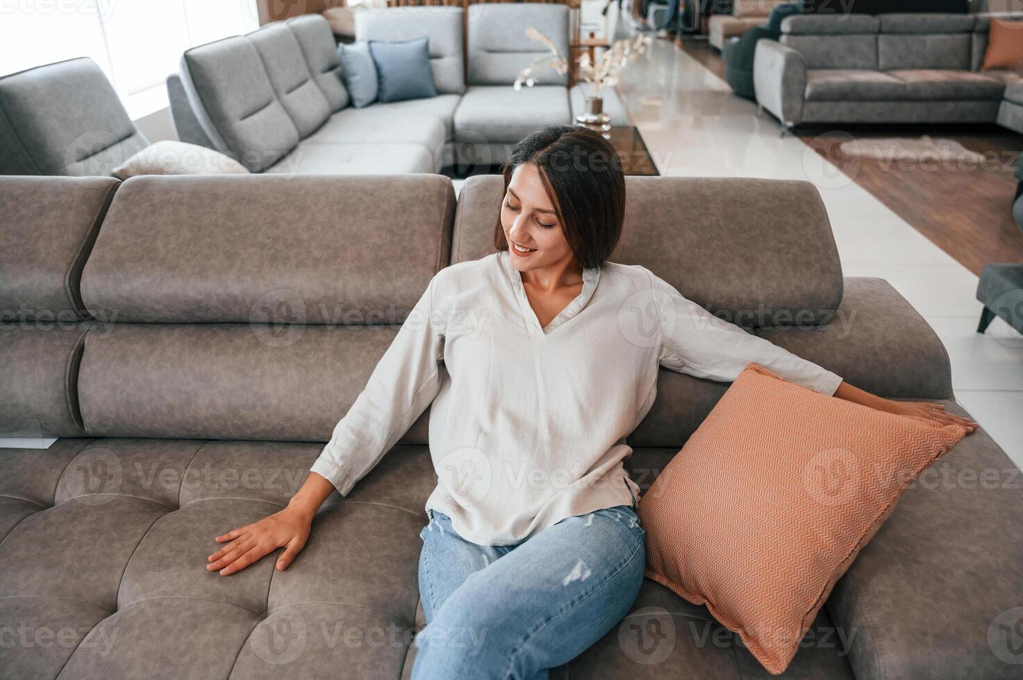 Woman ,is visiting bed store. Looking for comfortable sofa photo