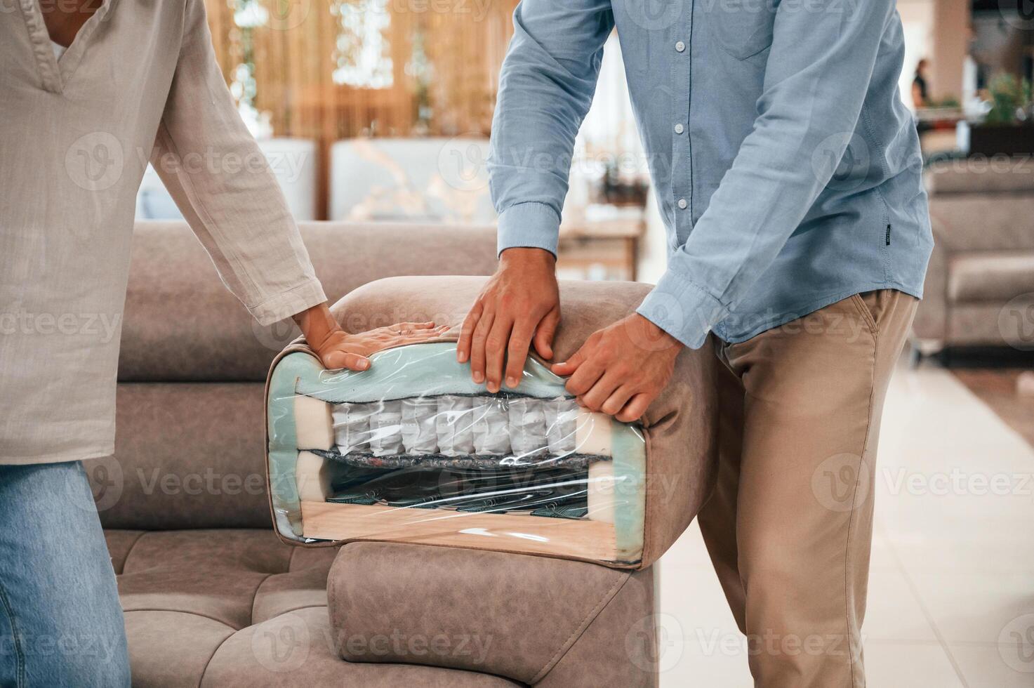 Smooth material. Couple, choosing the sofa and bed in the store photo