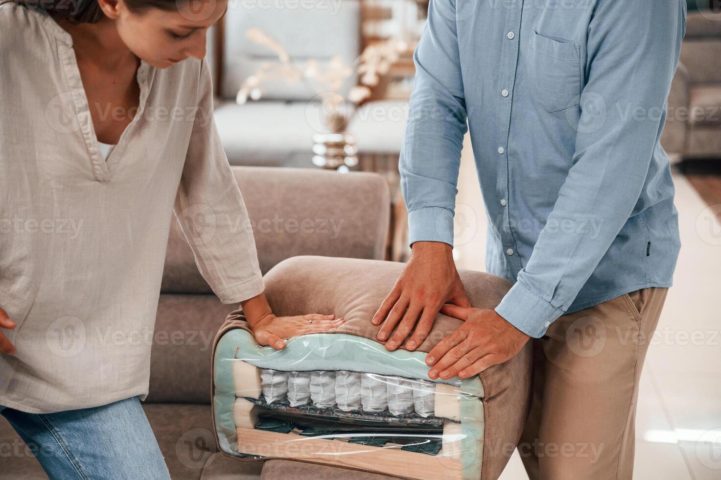 Smooth material. .Couple choosing the sofa and bed in the store photo