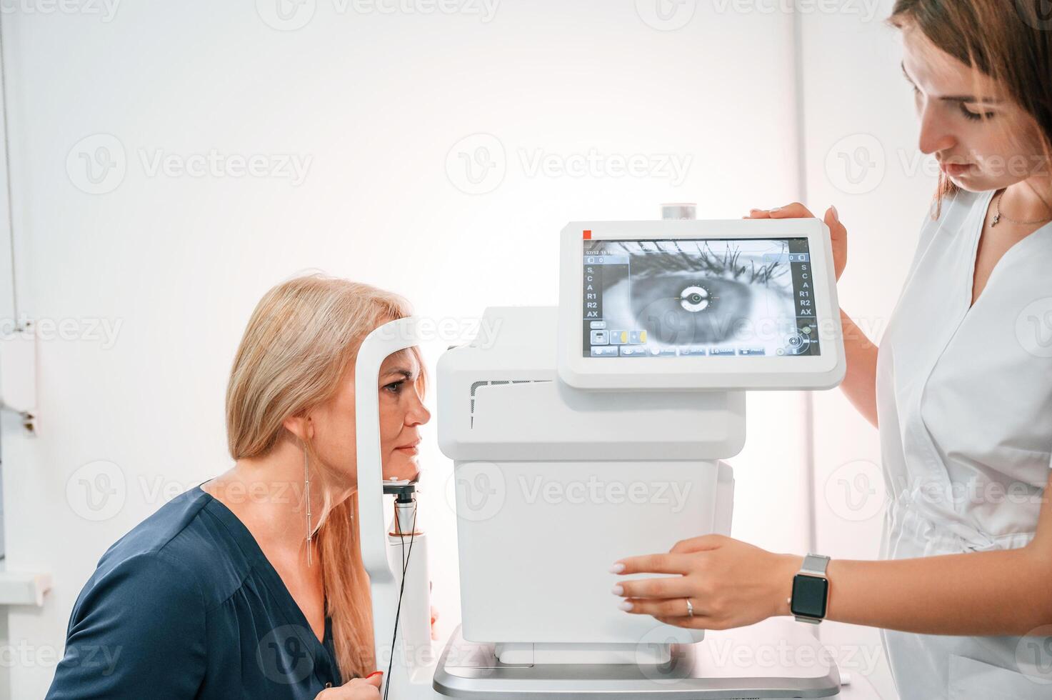 Side view. .Woman's vision is tested by clinic worker that using special device photo