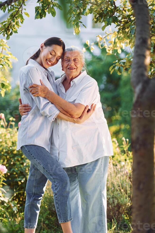 Conception ,of love to a parent. Young woman is with her senior mother is in the garden photo