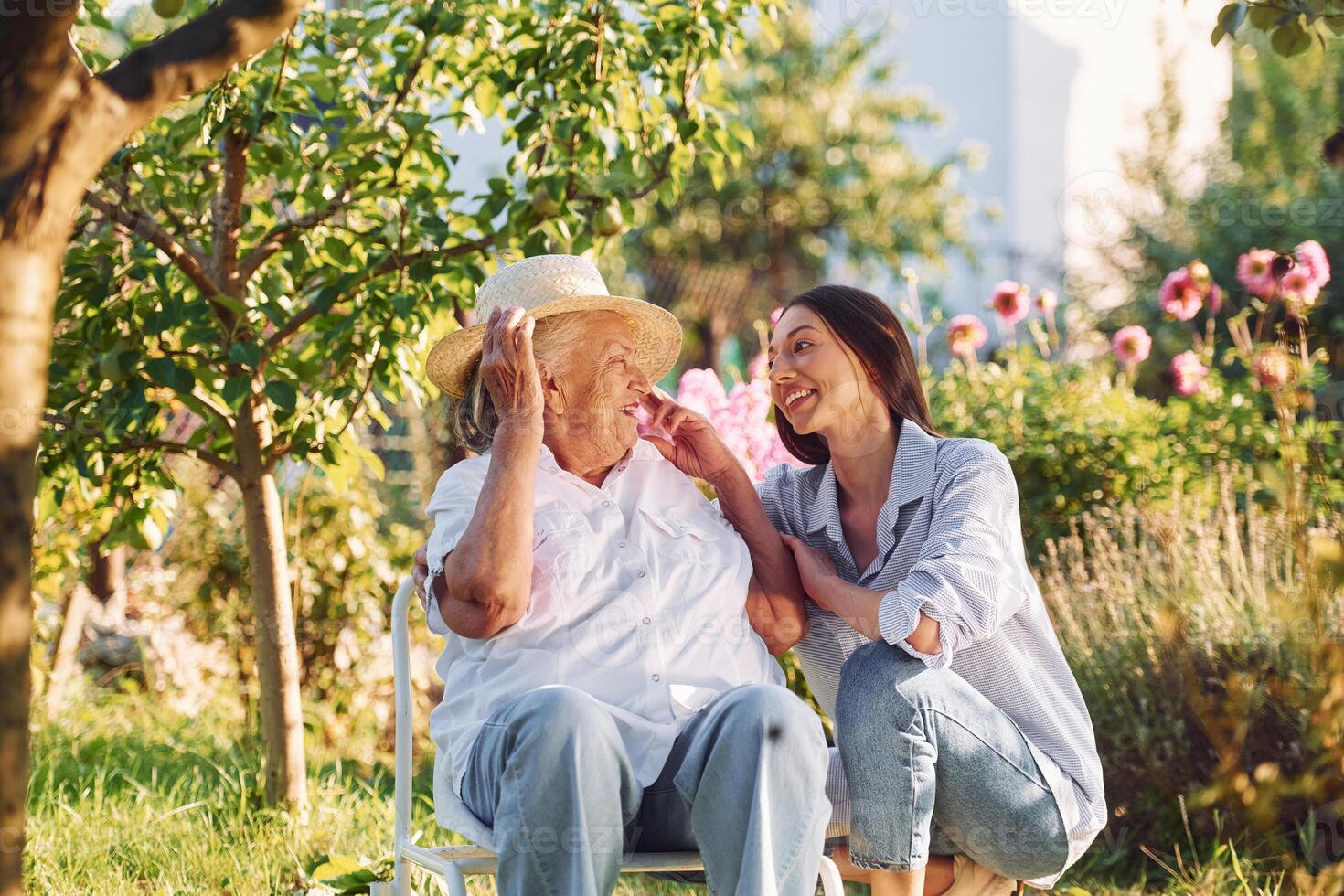 Sitting together. .Young woman ,is with her senior mother is in the garden photo