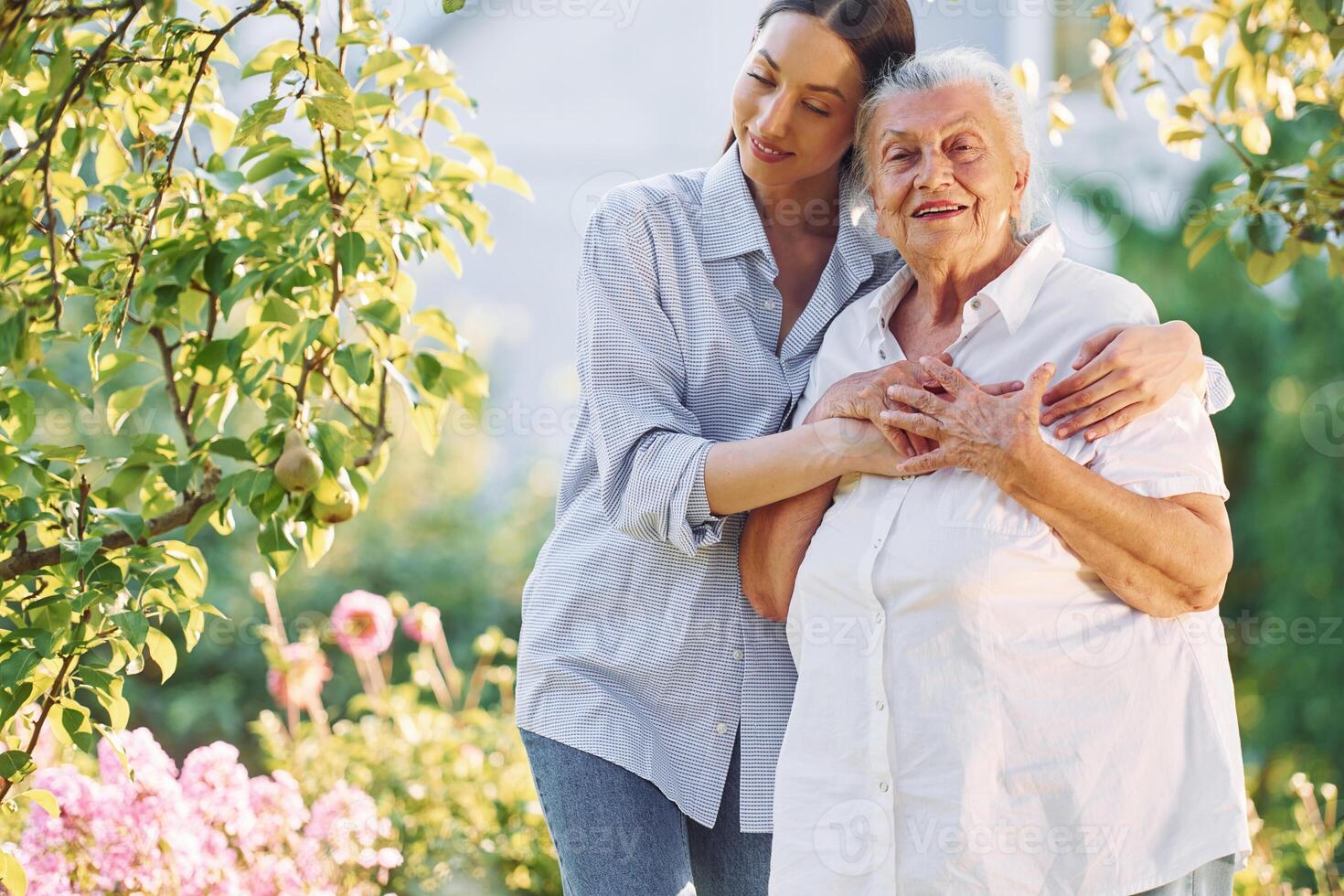 Conception of, love to a parent. Young woman is with her senior mother is in the garden photo