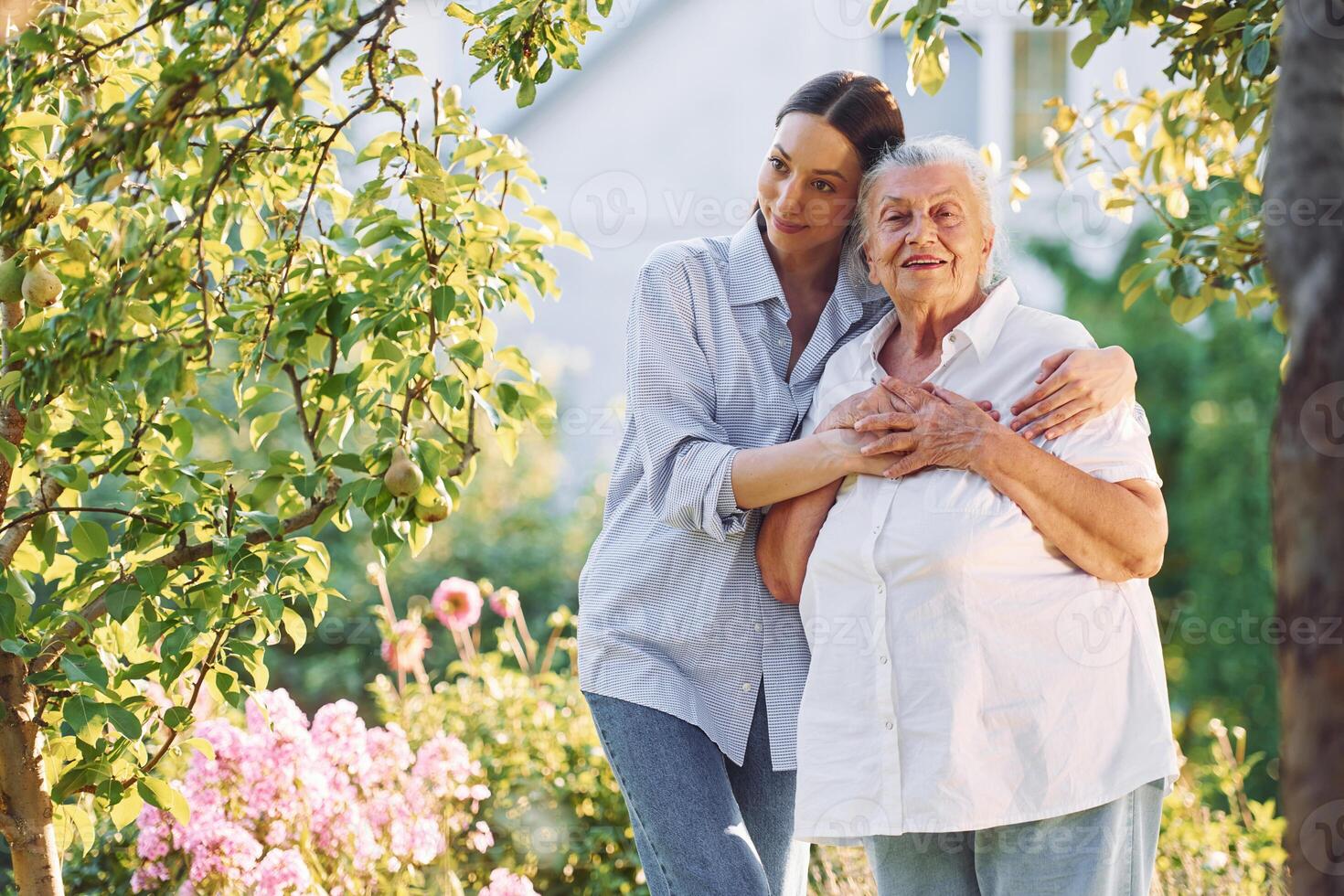 Conception of love ,to a parent. Young woman is with her senior mother is in the garden photo