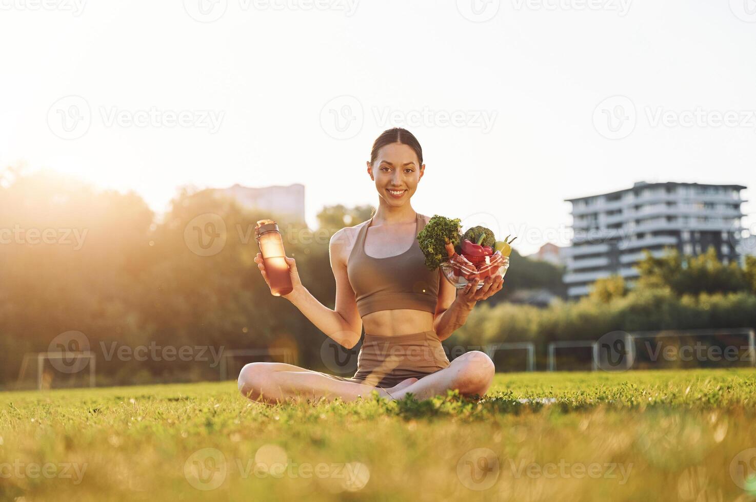 Conception, of diet. Healthy food. Young woman in yoga clothes is outdoors on the field photo