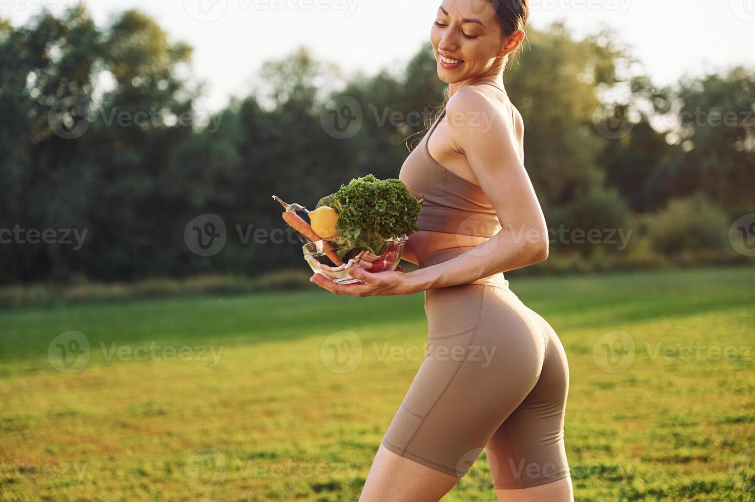Diet ,and weight loss conception. Young woman in yoga clothes is outdoors on the field photo