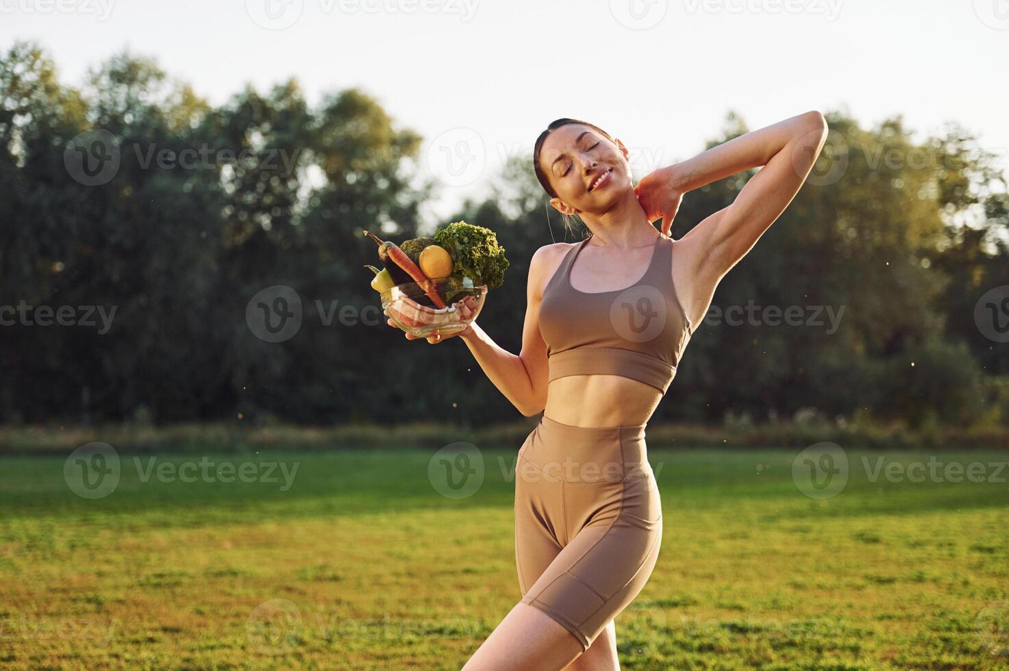 Diet and ,weight loss conception. Young woman in yoga clothes is outdoors on the field photo