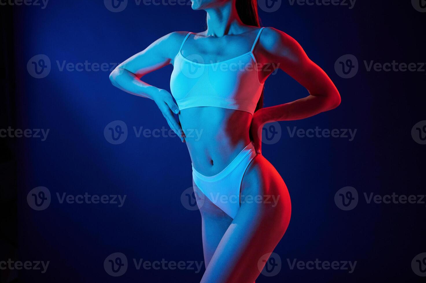 Taking a closer look.. Young woman in underwear is in the studio with neon lights photo