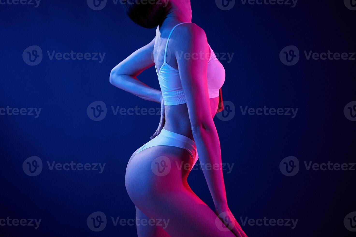 Side view. Young woman ,in underwear is in the studio with neon lights photo