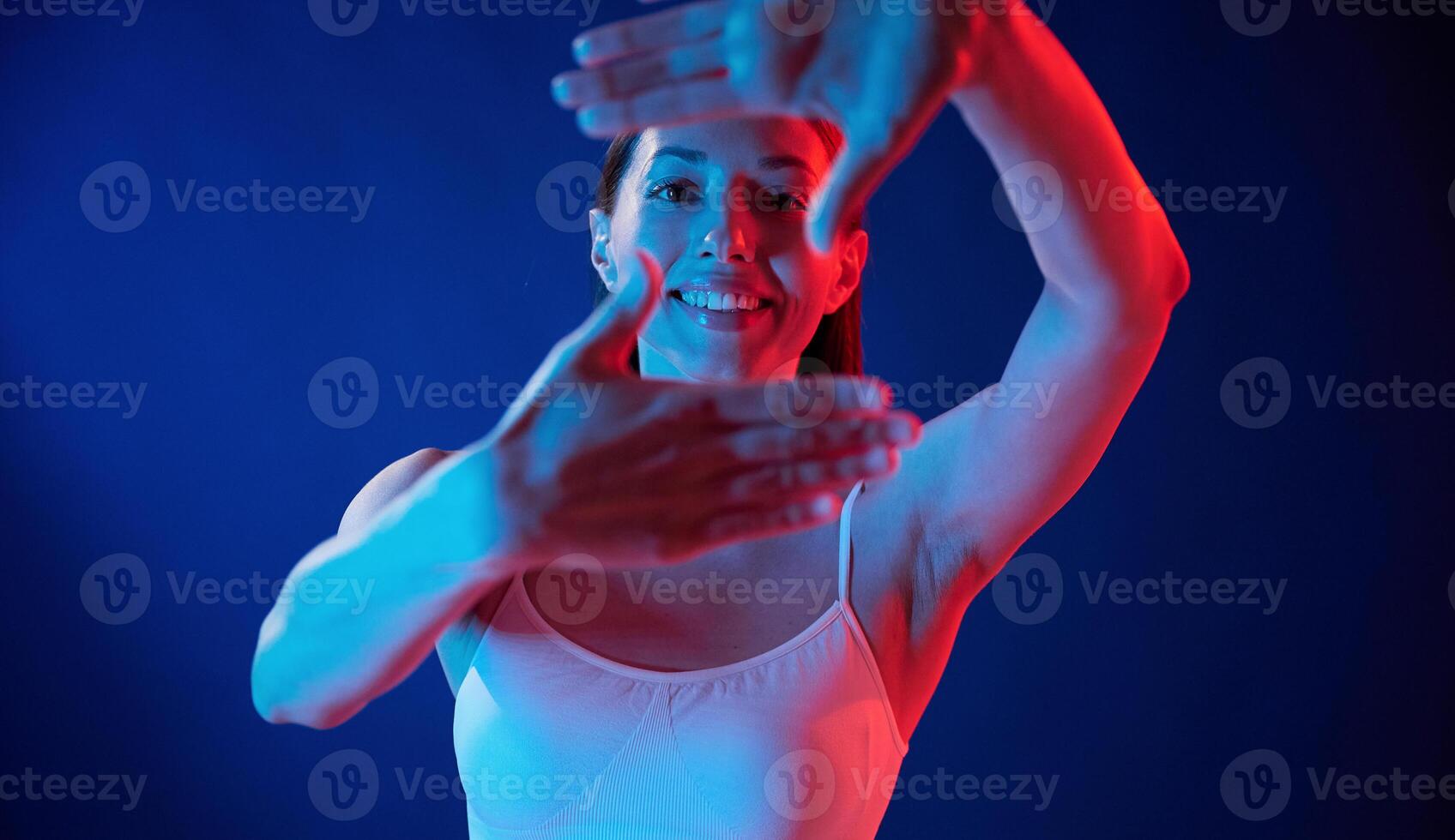 Doing, gestures ,by the hands. Young woman in underwear is in the studio with neon lights photo
