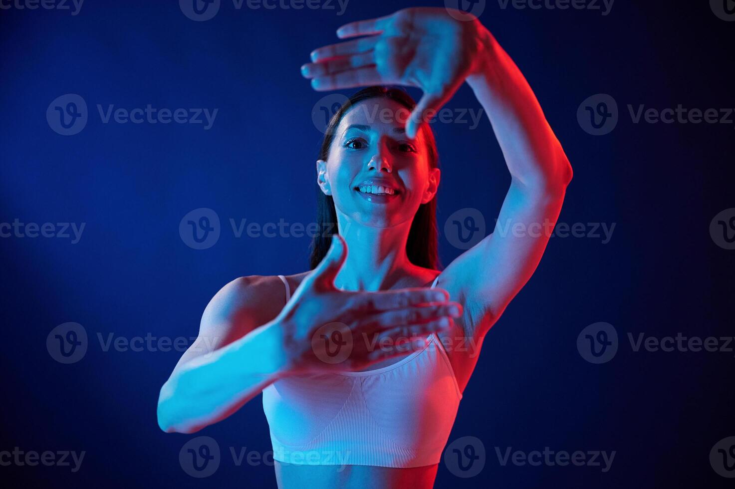 Doing, gestures by the hands.. Young woman in underwear is in the studio with neon lights photo