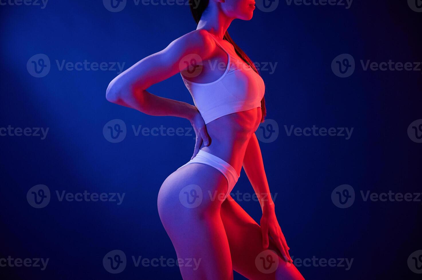 Side ,view. Young woman ,in underwear is in the studio with neon lights photo
