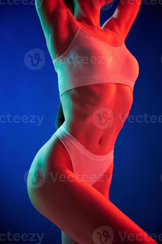 Illuminated, by red color. Young woman ,in underwear is in the studio with neon lights photo
