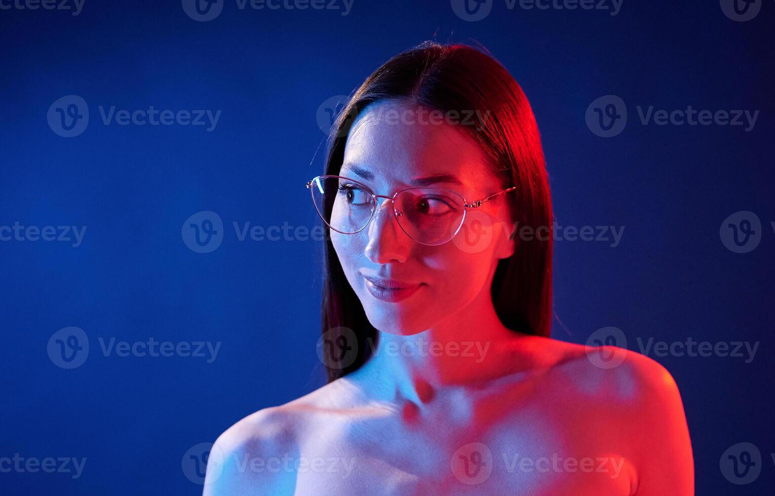 Conception ,of bad sight, in glasses. Portrait of young woman that is indoors in neon lighting photo