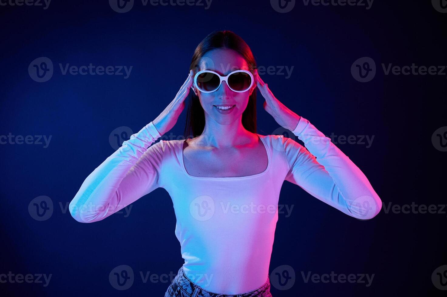 In sunglasses. Portrait ,of young woman that is indoors in neon lighting photo