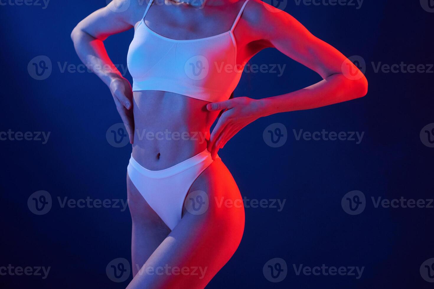 Fitness type body. Young ,woman in underwear is in the studio with neon lights photo