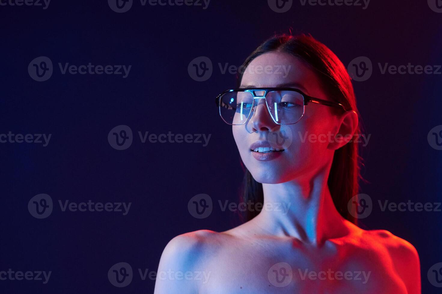 Beautiful look. Portrait of young woman t,hat is indoors in neon lighting. photo