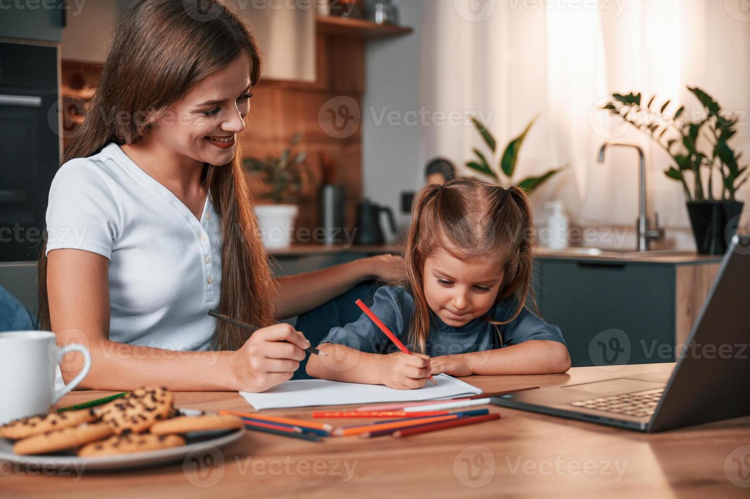Learning ,how to draw. Young mother with her daughter is together at apartment photo