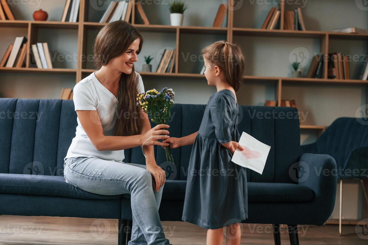Young mother with her daughter is together at apartment photo