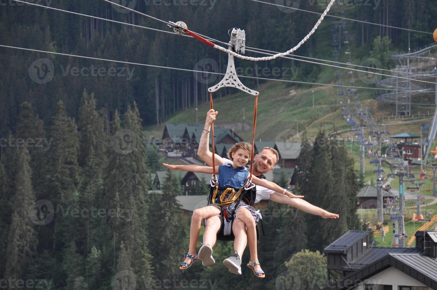 Happy, father with his daughter is on the ski lift having fun and smiling. Majestic view of Carpathians photo