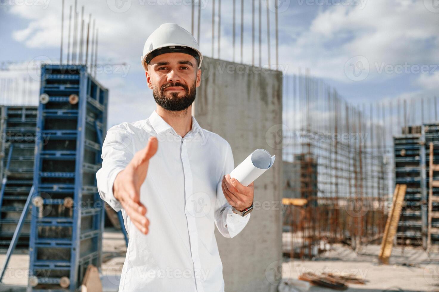 Engineer extends, his hand. Man in uniform ,is working on the construction site photo