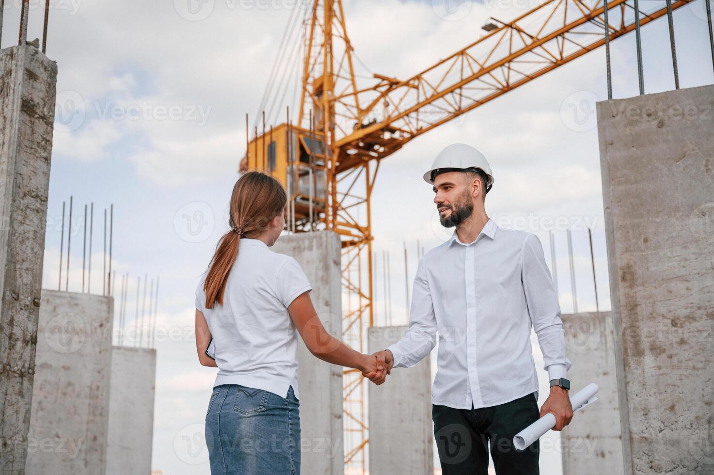 Doing ,handshake. Successful agreement. Man in uniform working with woman on the construction site photo
