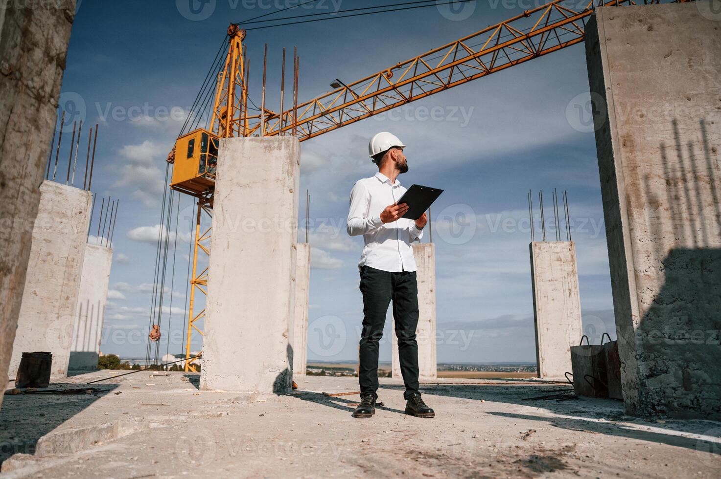 Inspector ,with notepad is standing on the, construction site photo