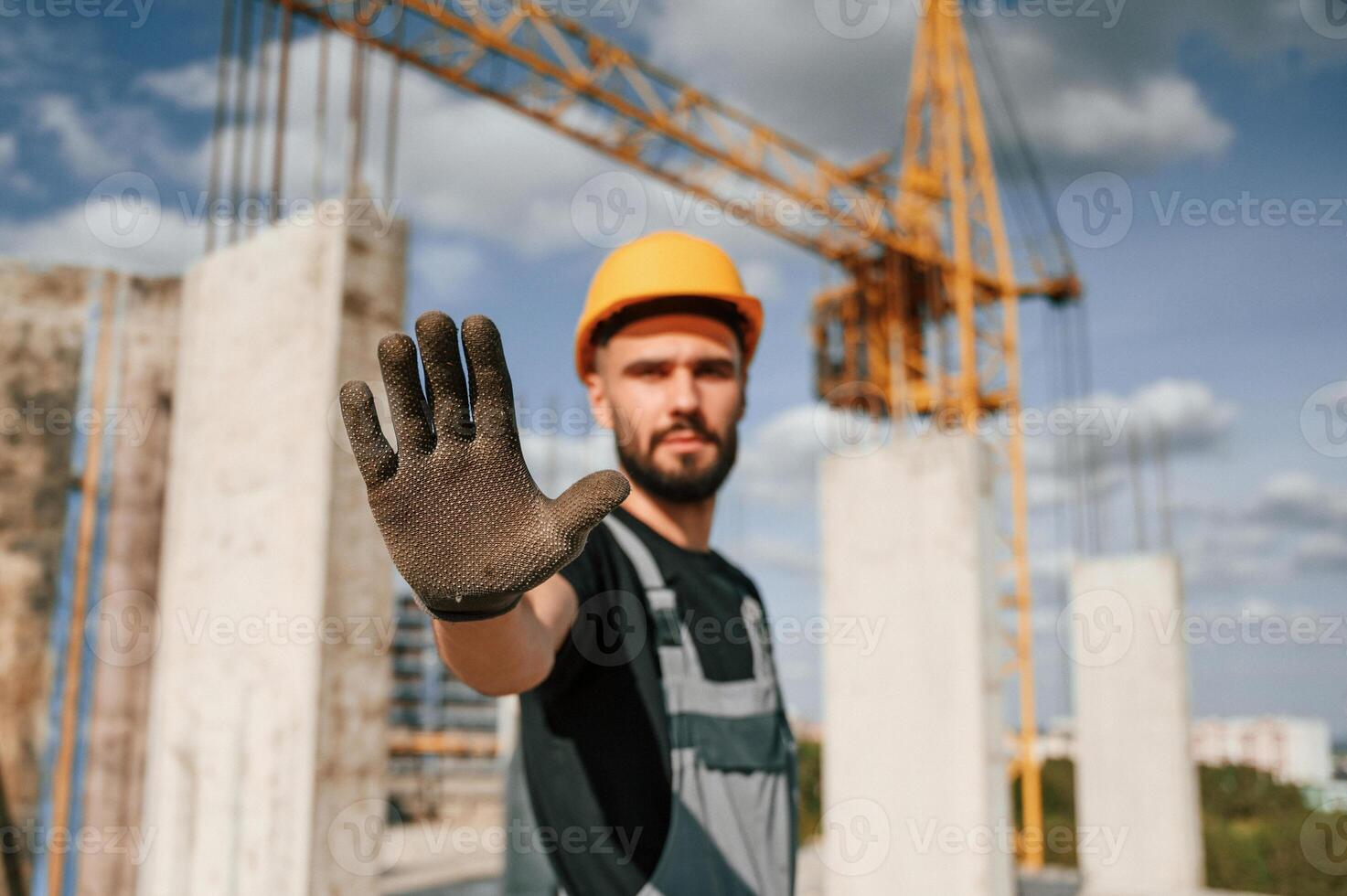Stop ,gesture. Man in uniform is working on the construction site photo