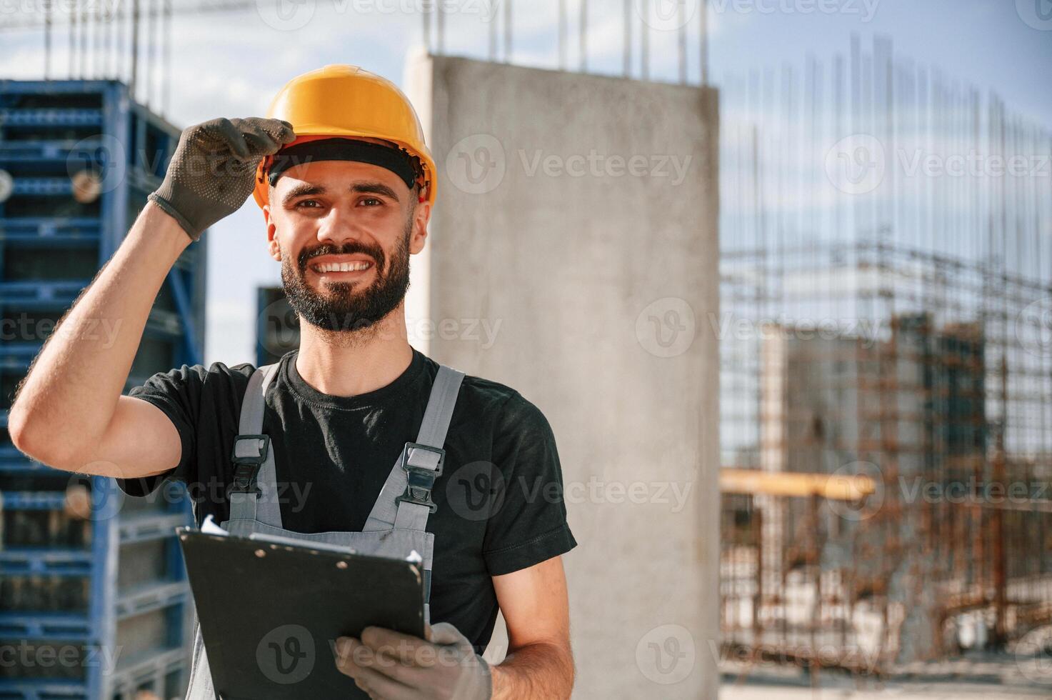 Posing for a camera, with notepad. Beautiful portrait. Man in uniform is working on the construction site photo
