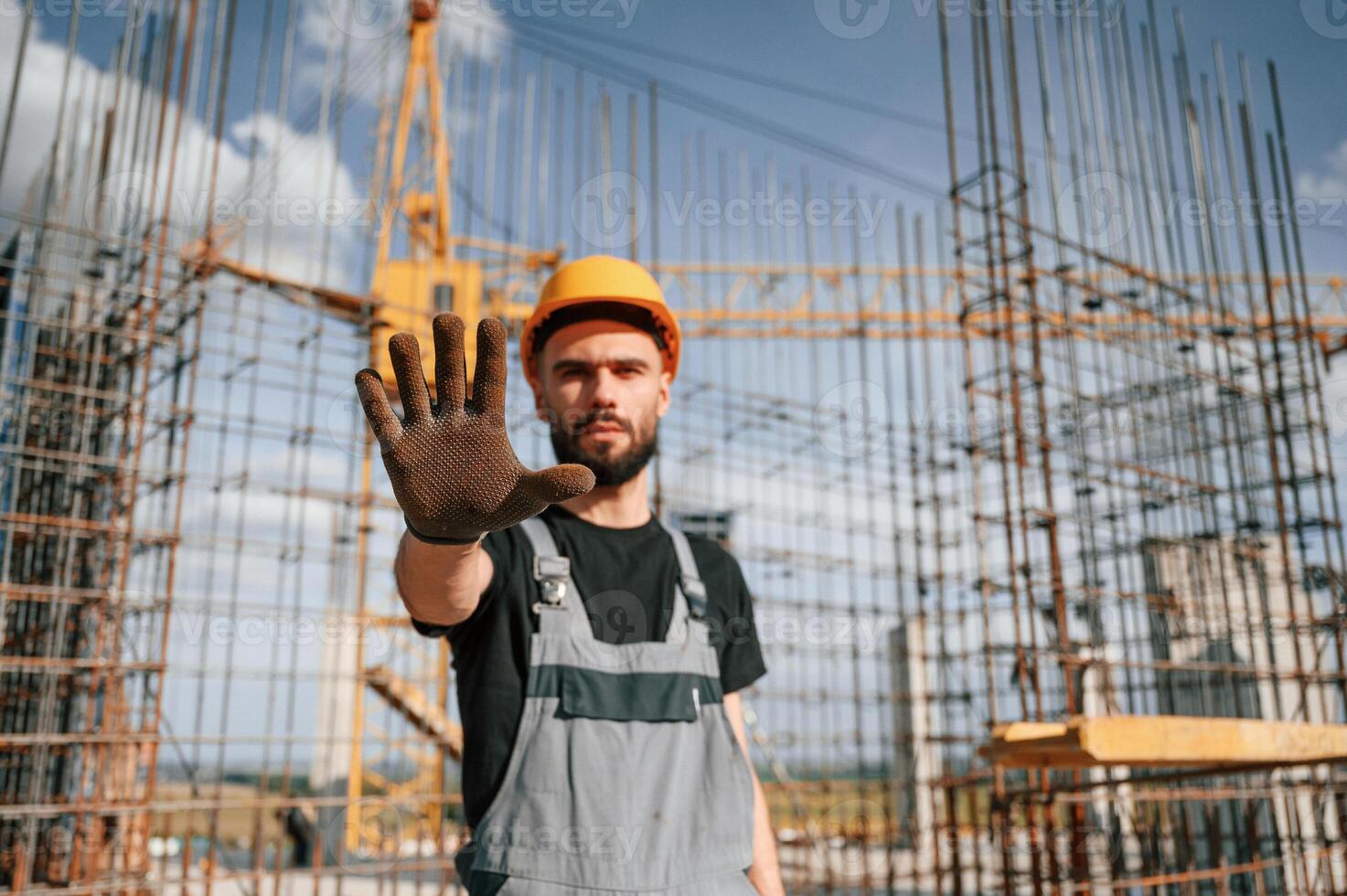Closed area.. Stop gesture. Man in, uniform is working on the construction site photo