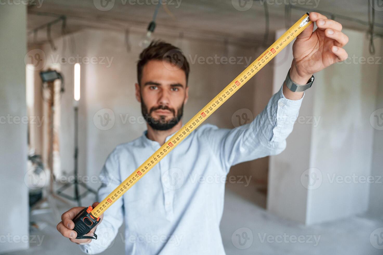 Holding ruler measurement, tool. The man is making repairs in the apartment photo