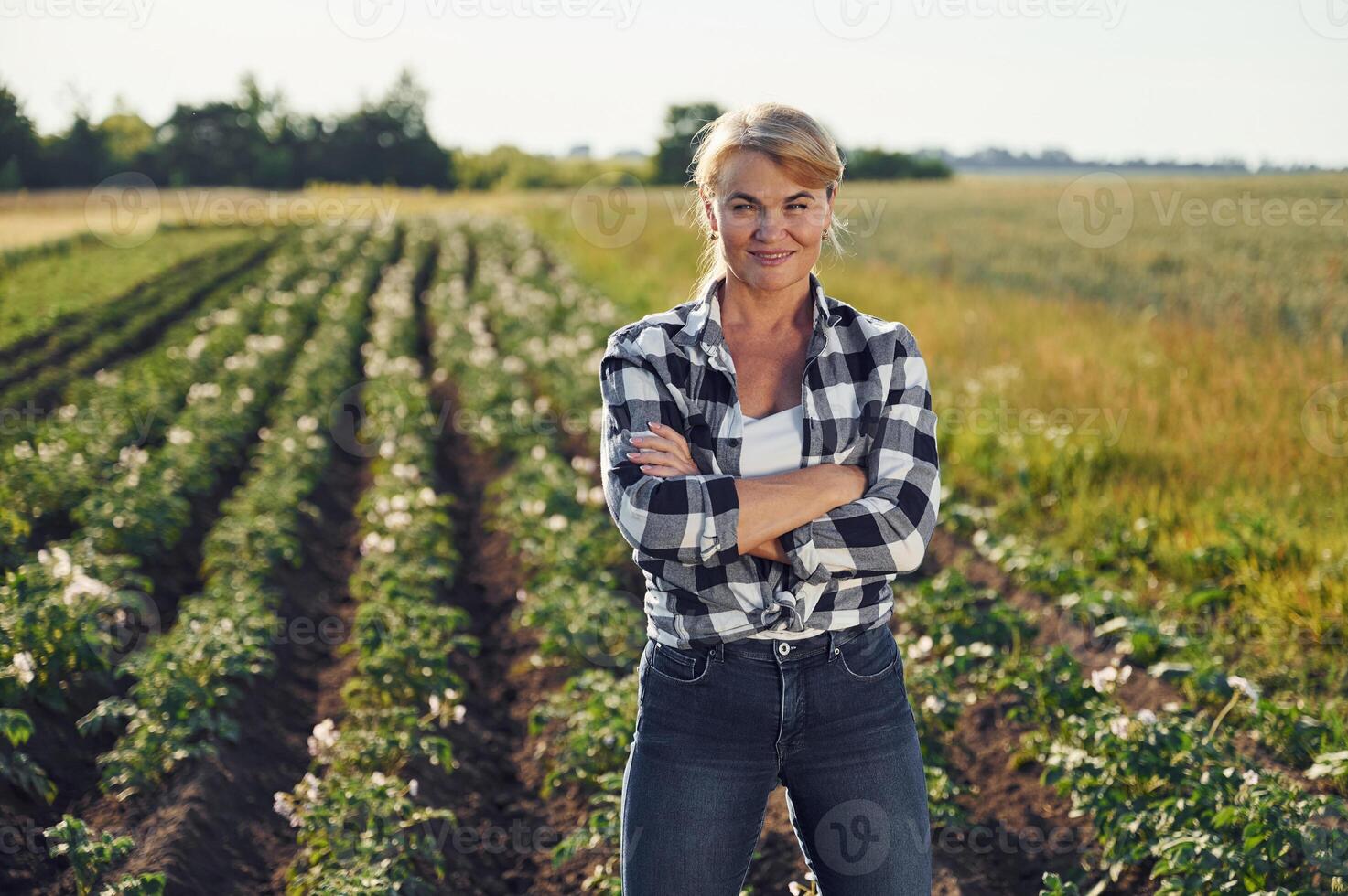 Standing, and posing. Woman is on the agricultural field at daytime photo