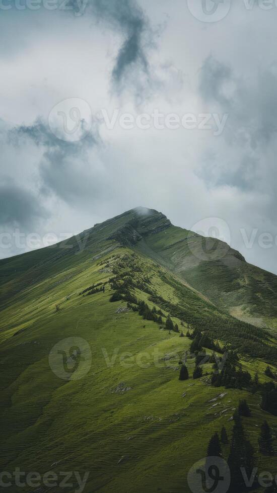 A mountain with a green grassy hill and clouds photo