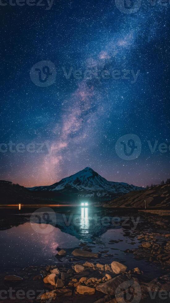 The milky way over a lake with rocks and mountains in the background photo