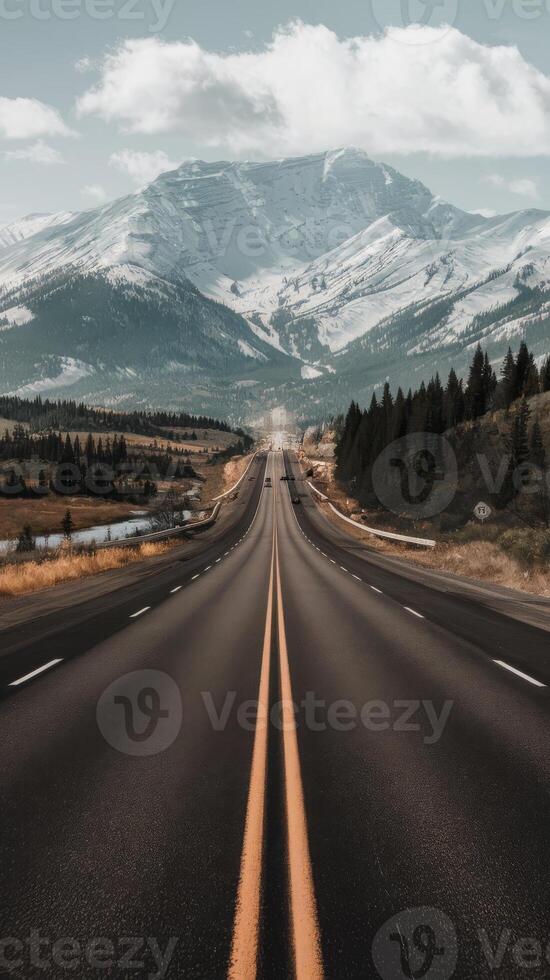 An empty highway with mountains in the background photo