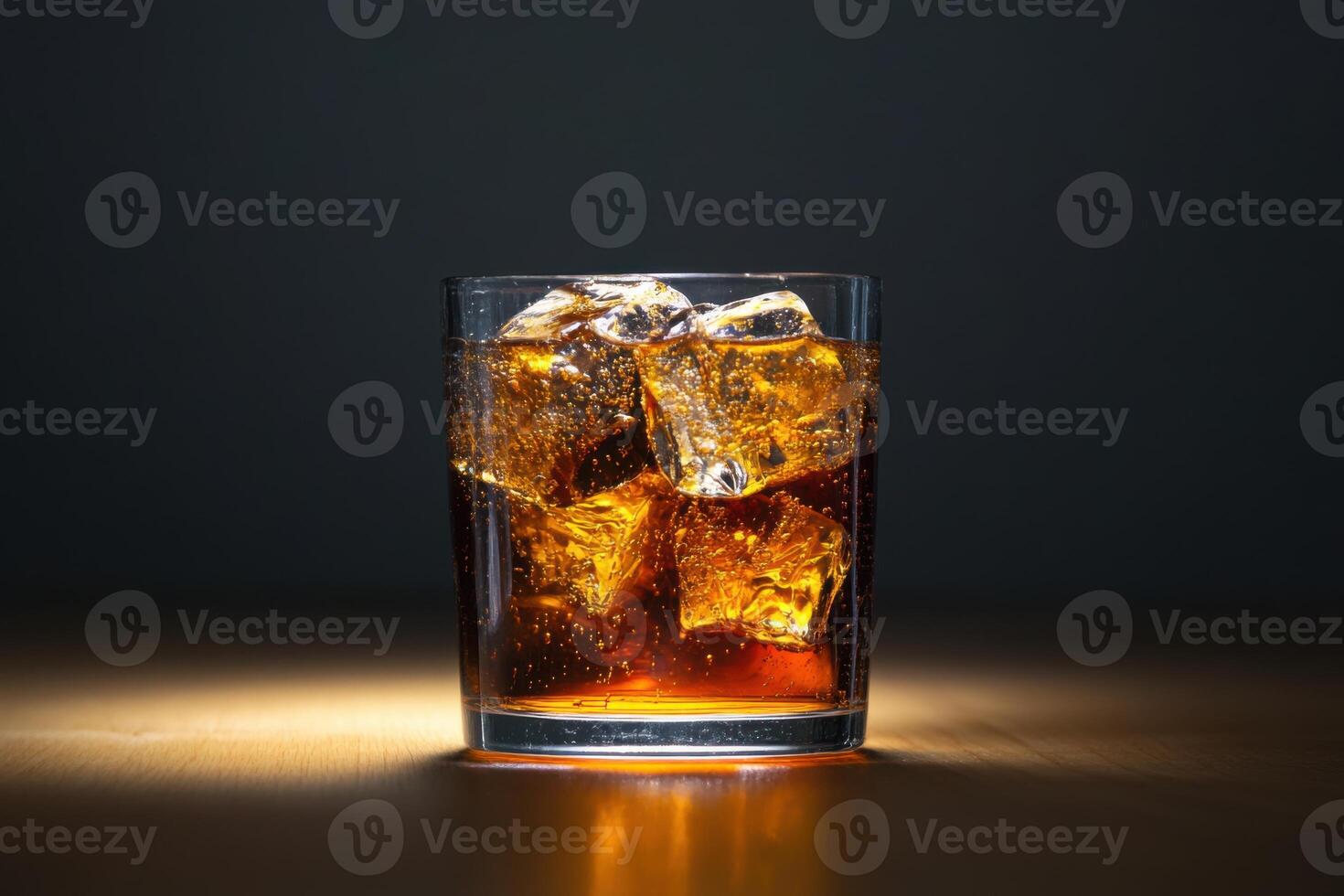 A glass of cola with ice cubes on a table photo