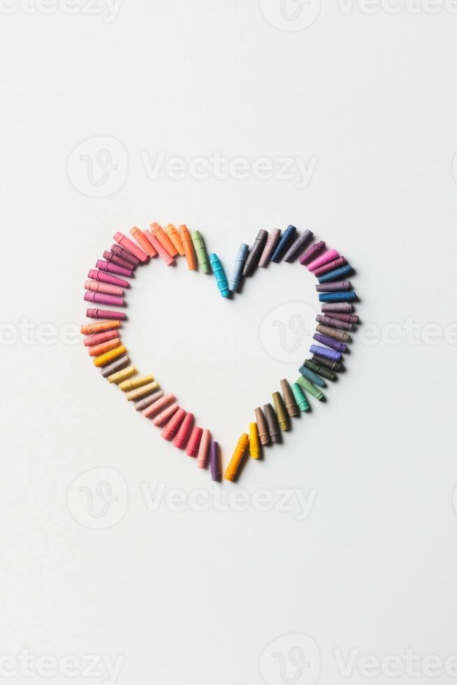 Heart shape crafted from colorful crayons on a white background showcases the joy of artistry and imagination photo