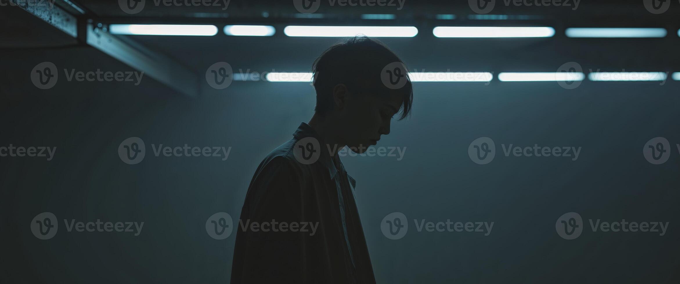 A man standing in a dark room with a light shining on him photo