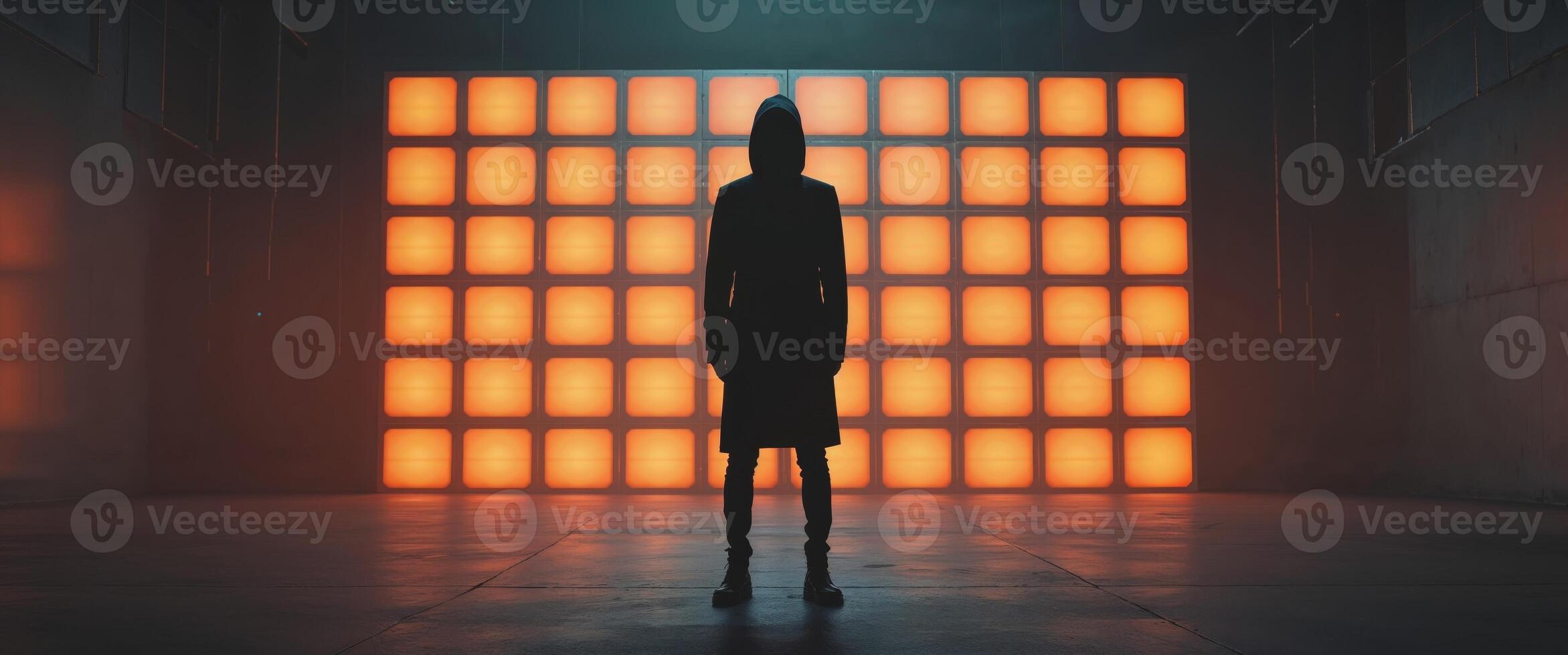 A person standing in front of a wall of orange lights photo