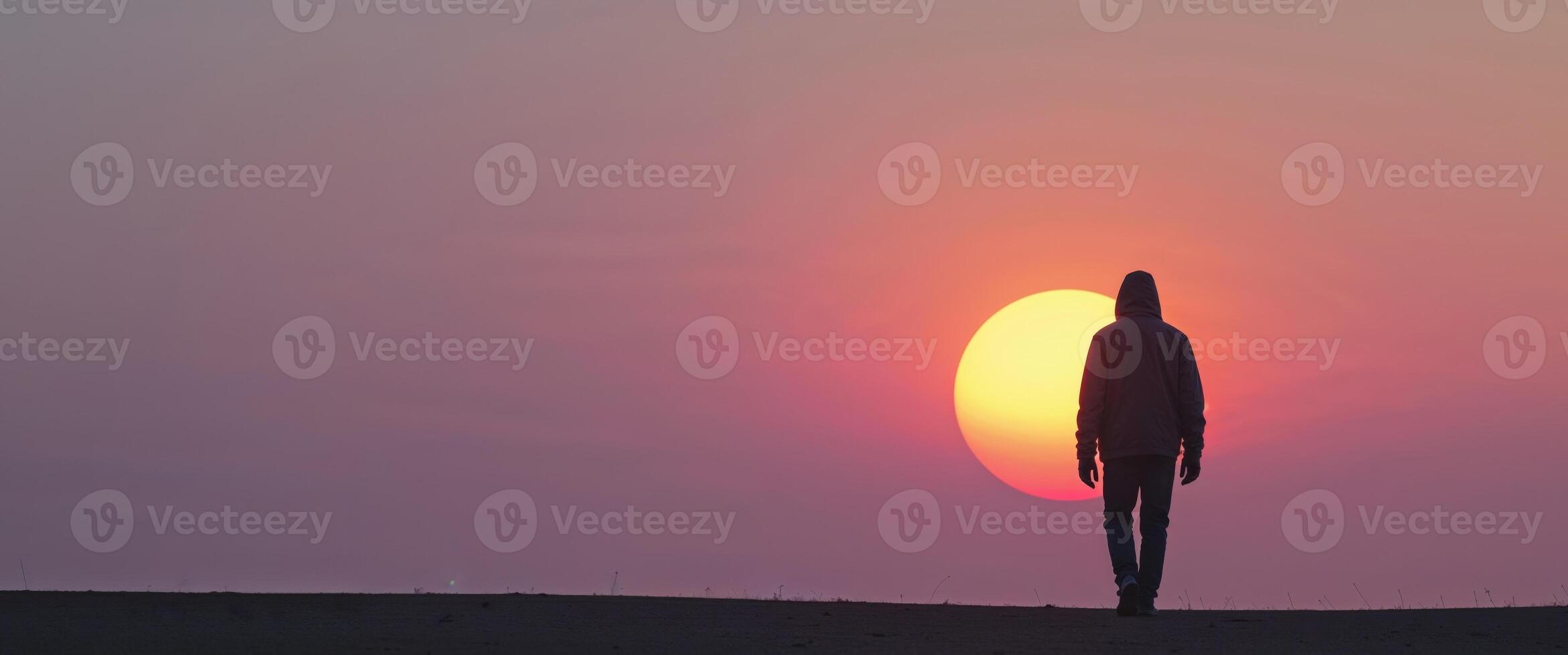 Solitary Figure Walking Towards the Setting Sun. photo