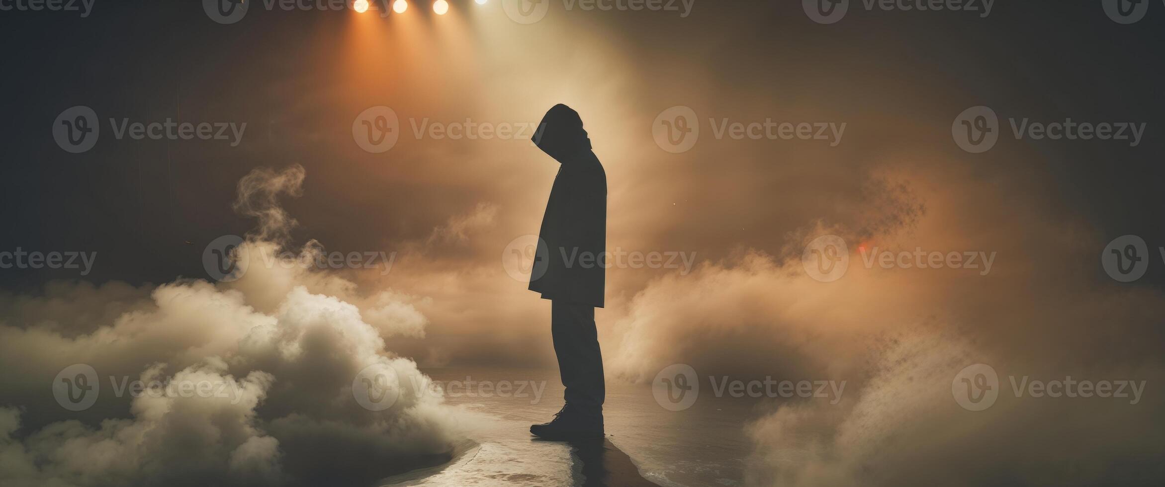 Silhouette Person Stands in Smoky Stage Lighting. photo