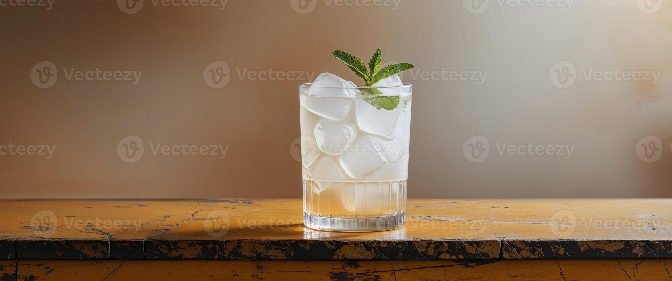 Refreshing drink served in a glass filled with ice on a wooden bar top in a casual setting. photo