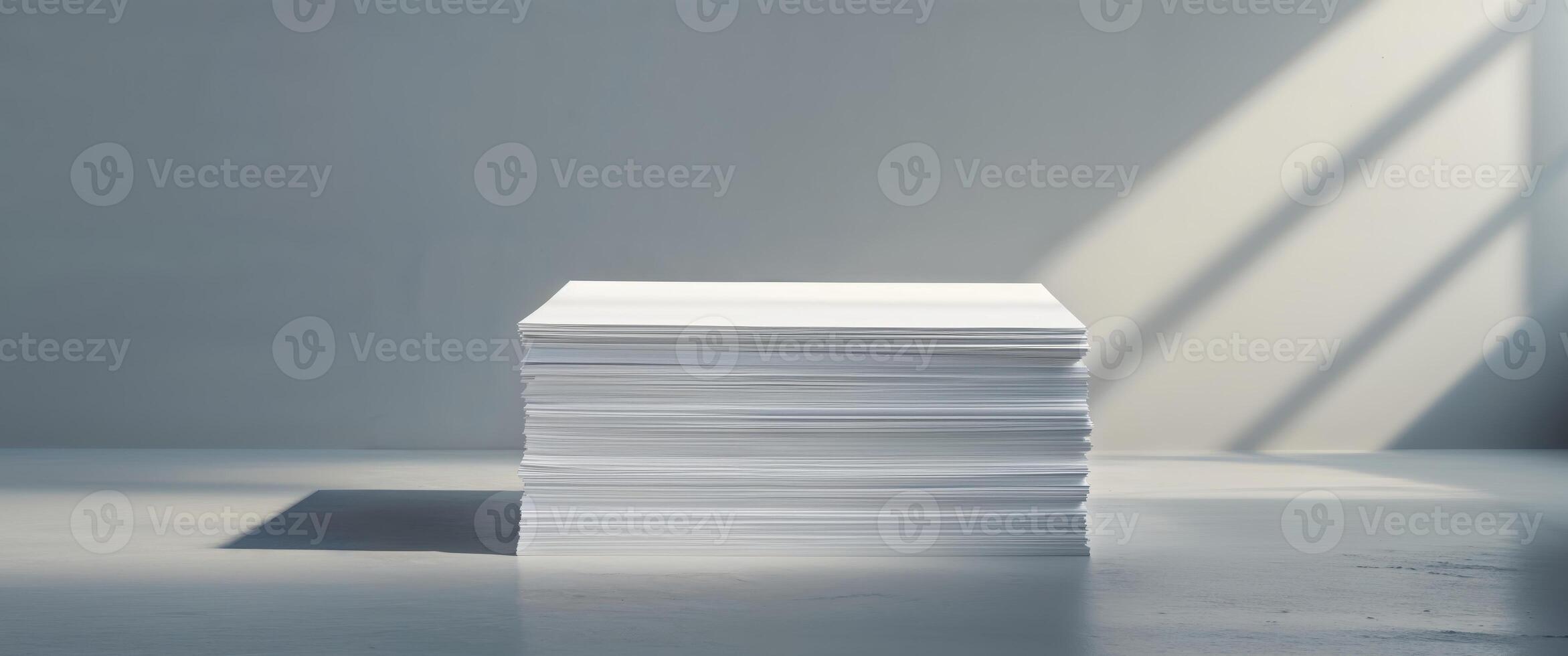 Stack of white paper on a table in front of a window photo