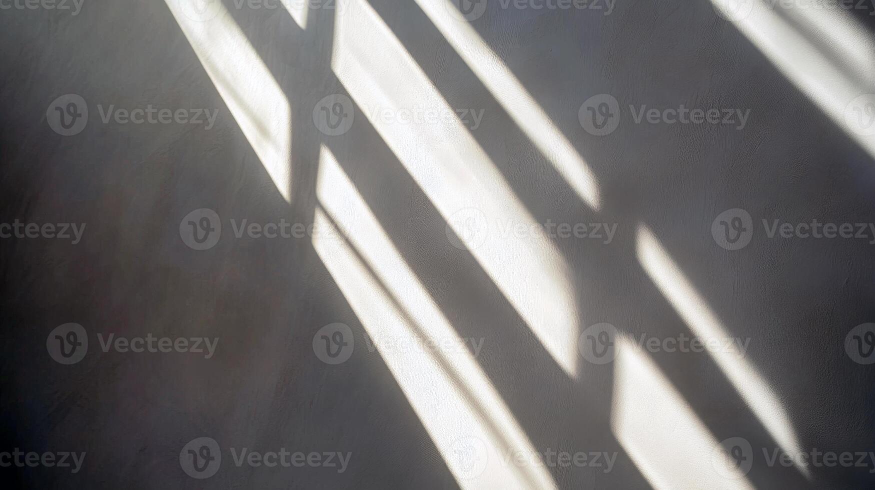 Sunlight casting window shadows on a wall in a minimalist setting photo
