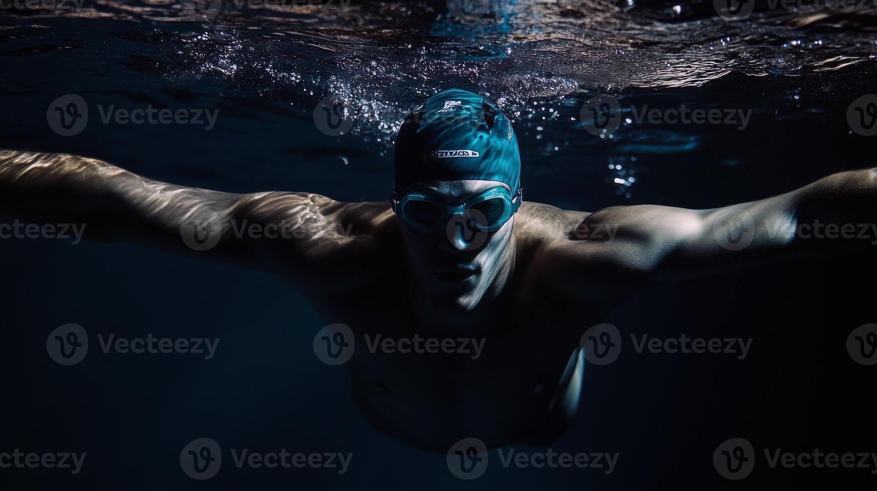 Young caucasian male swimmer in action underwater with goggles and swim cap photo