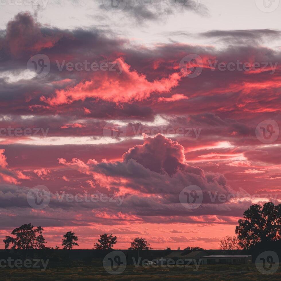 A red sky with clouds over a field photo