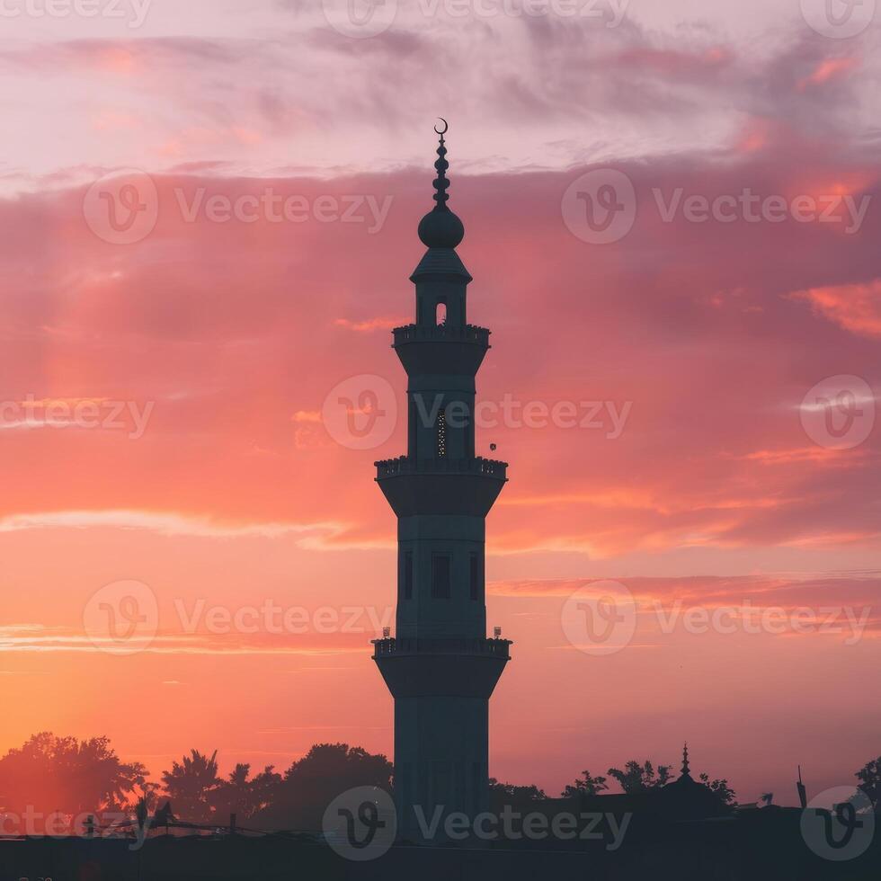 A mosque tower at sunset with clouds in the background photo