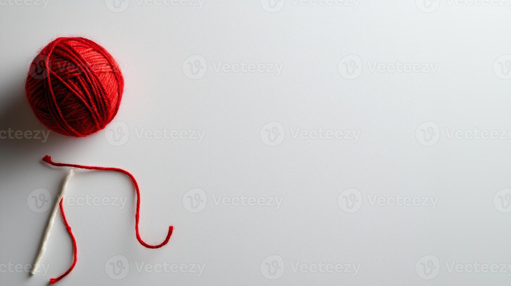 single red yarn ball with needle on white background, minimalistic style photo