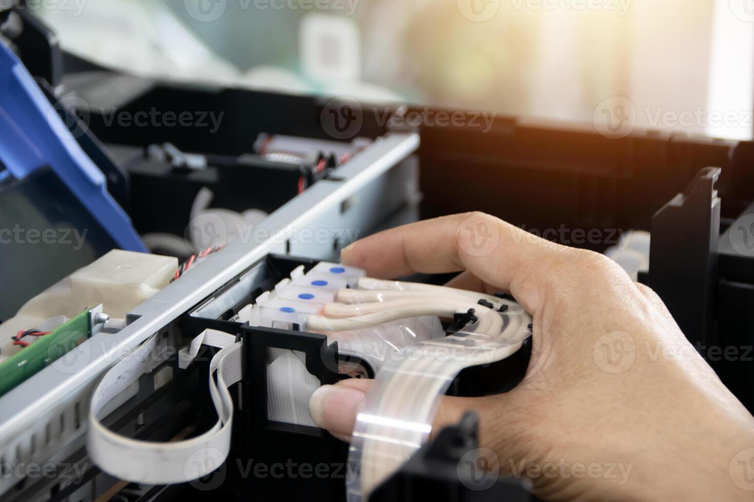 The technician is aligning the print head and repairing the printer. photo