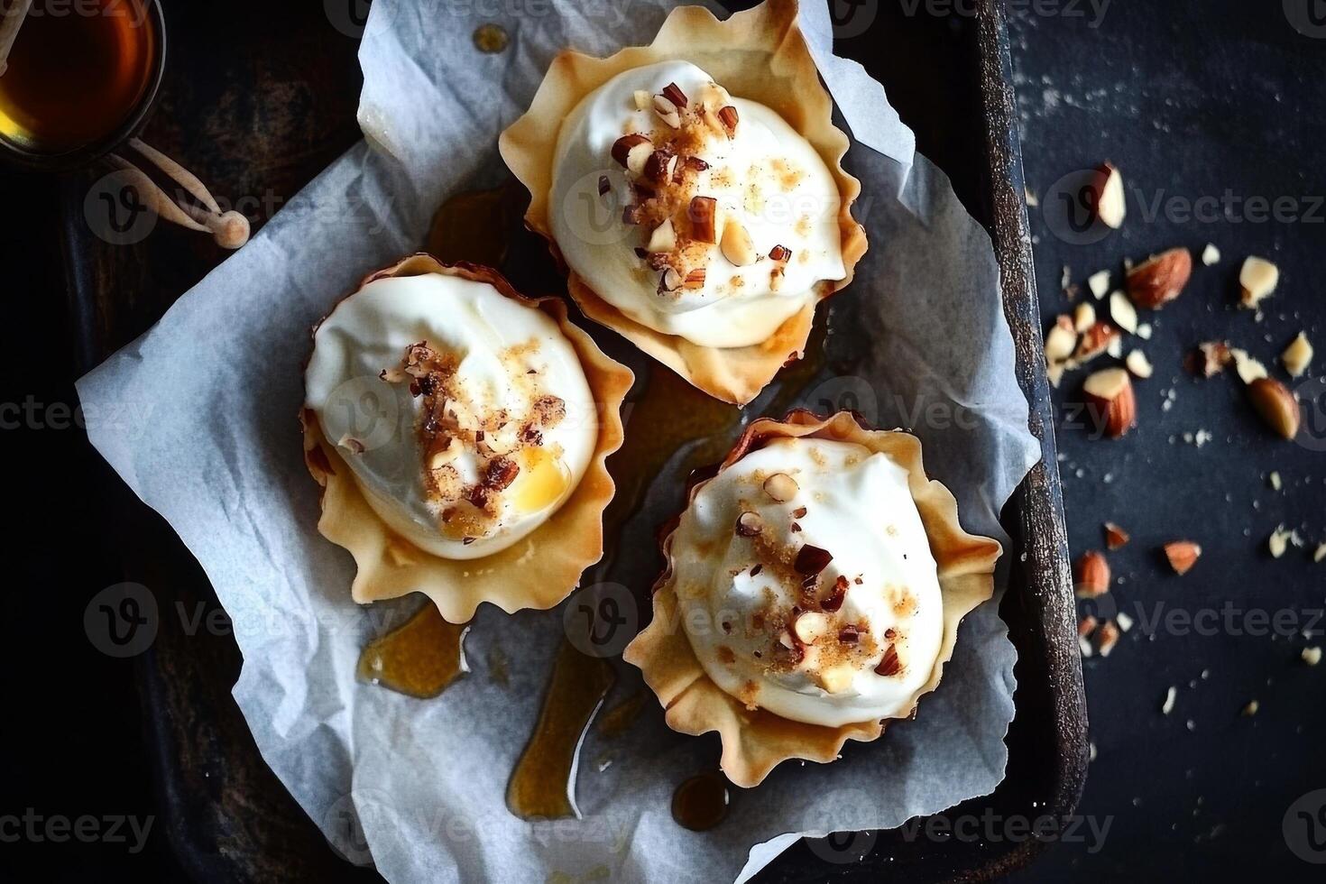 Delicious tartlets filled with Greek yogurt and topped with nuts and honey on a rustic serving tray photo